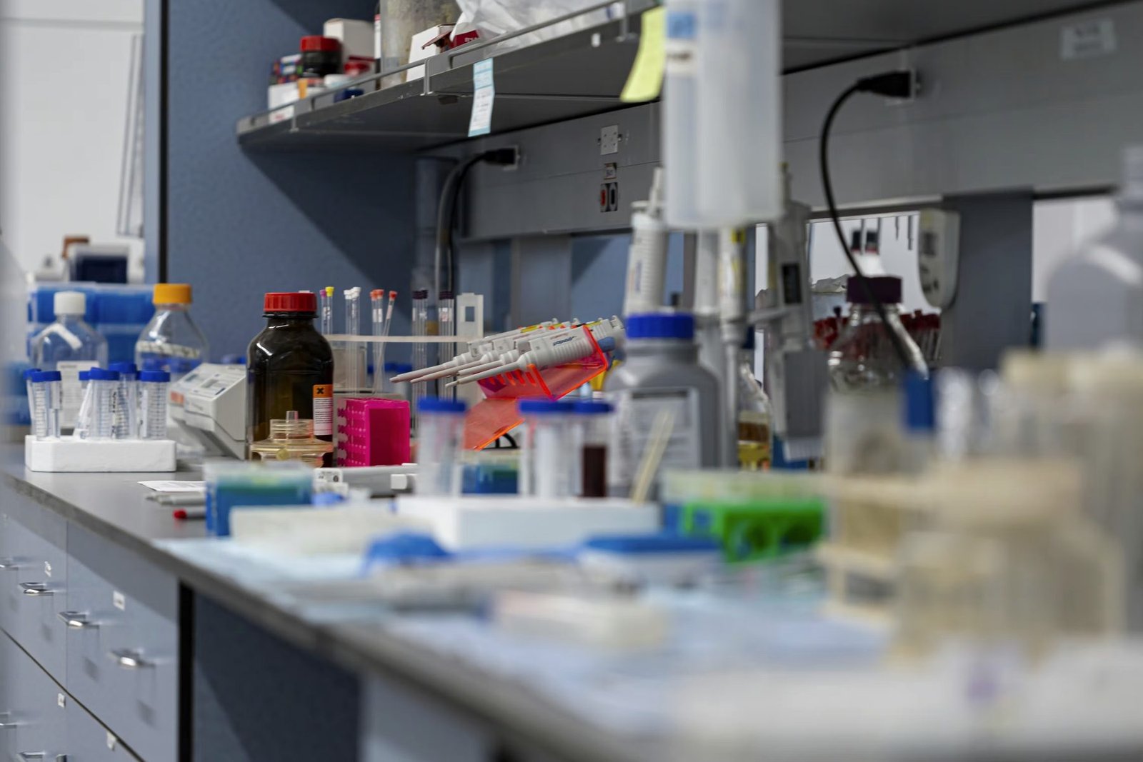 A research bench with pipettes, reagent bottles, and sample tubes in daylight